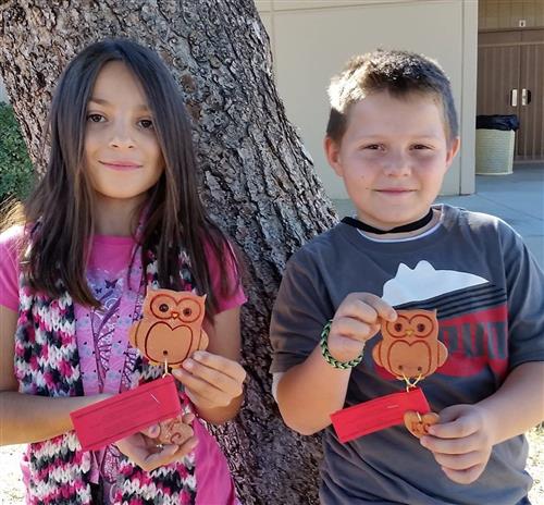 students with handmade owl ornaments